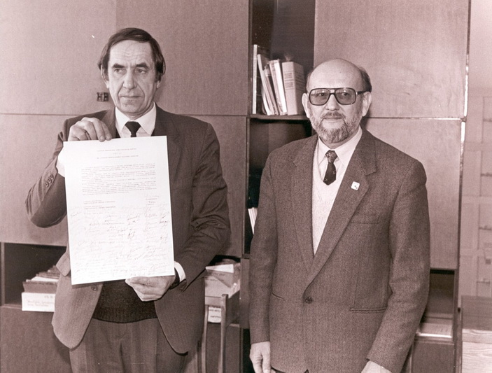 Bene jauniausio šalies archyvo įkūrimo tikslas buvo pradėti kaupti ką tik atkurtos nepriklausomos Lietuvos dokumentus. Nuotraukoje – Lietuvos centrinio valstybės archyvo direktorius Alfonsas Piliponis ir Lietuvos archyvų generalinės direkcijos prie LR Vyriausybės generalinis direktorius Gediminas Ilgūnas su Kovo 11-osios aktu. 1993-03-12. Fotografas Gediminas Svitojus. Lietuvos Respublikos Seimo archyvas. Ap. 24, VI-030-259.
